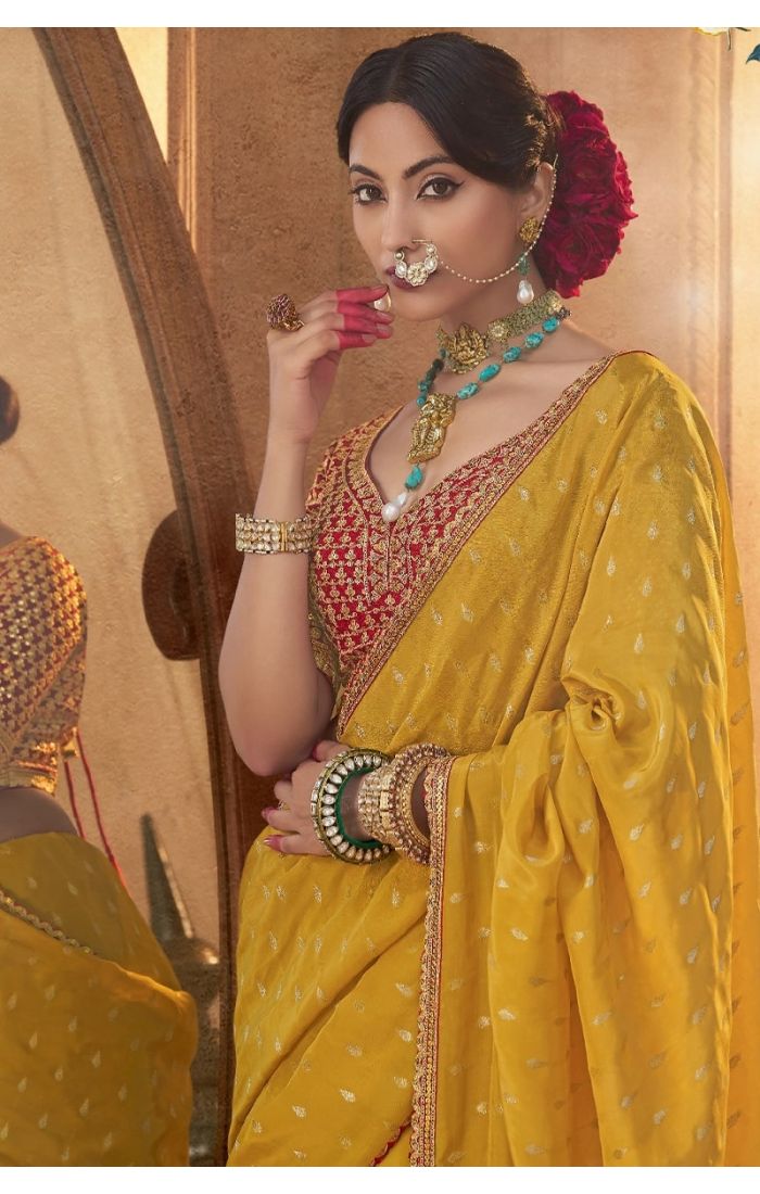 Close-up of weaving print & zari handwork on yellow saree fabric